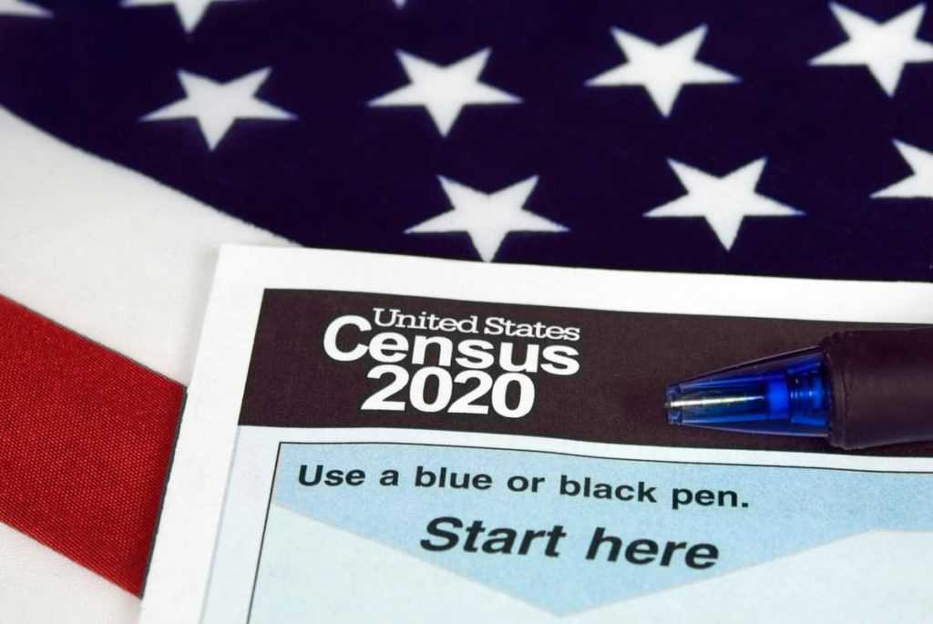 close up of 2020 census document form and ballpoint pen on American flag