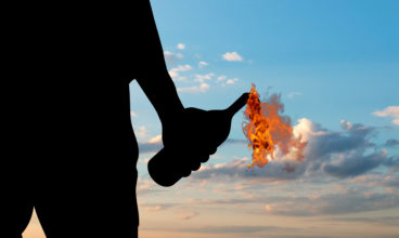 Silhouette of a terrorist holding a molotov cocktail