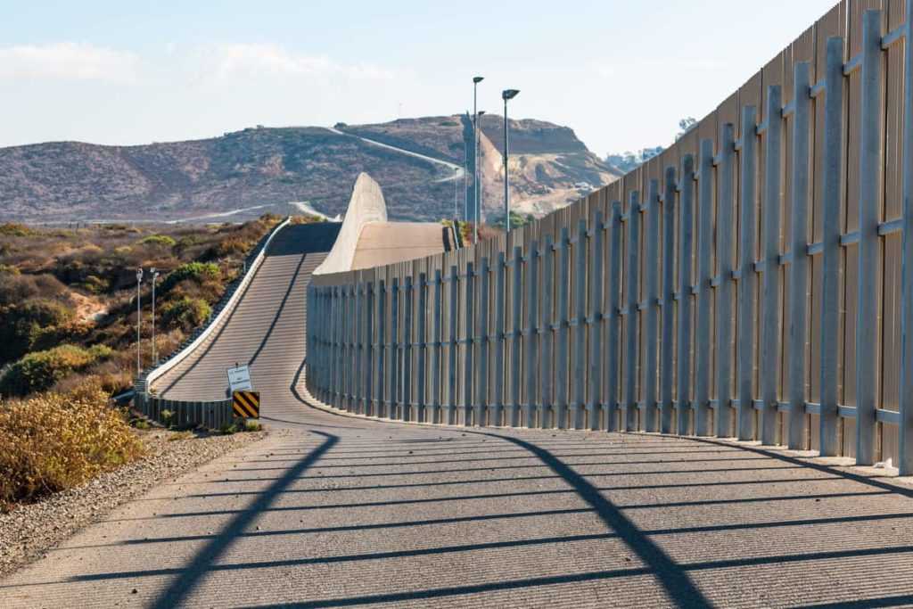 The international border wall between San Diego, California and Tijuana, Mexico, as it begins its journey from the Pacific coast and travels over nearby hills.