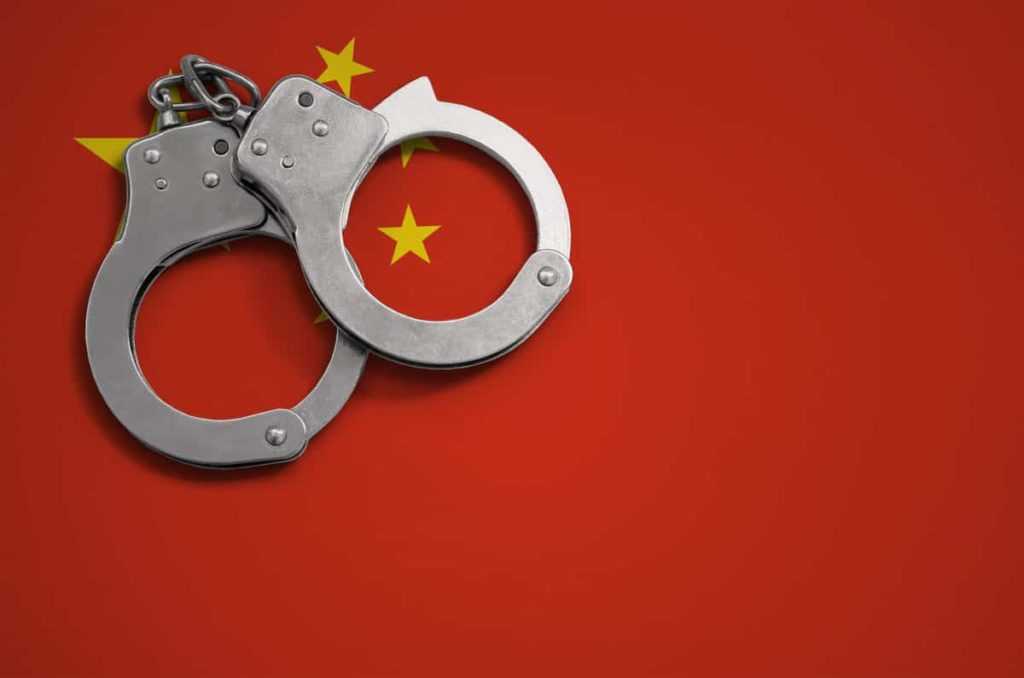 China flag  and police handcuffs. The concept of crime and offenses in the country