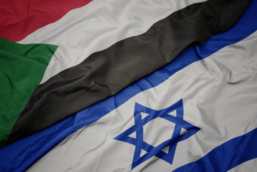 waving colorful flag of israel and national flag of sudan.