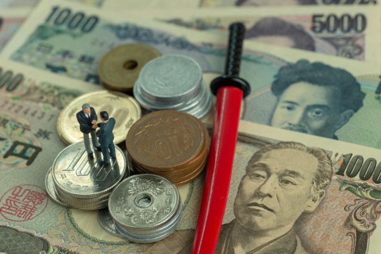 Japanese Yen in notes and coins and a miniature katana in red scabbard - miniature men shakes hand.