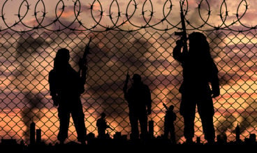 Silhouette terrorists near the border fence