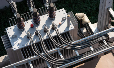 Top view of High voltage power transformer with electrical insulation and electrical equipment in power substation.