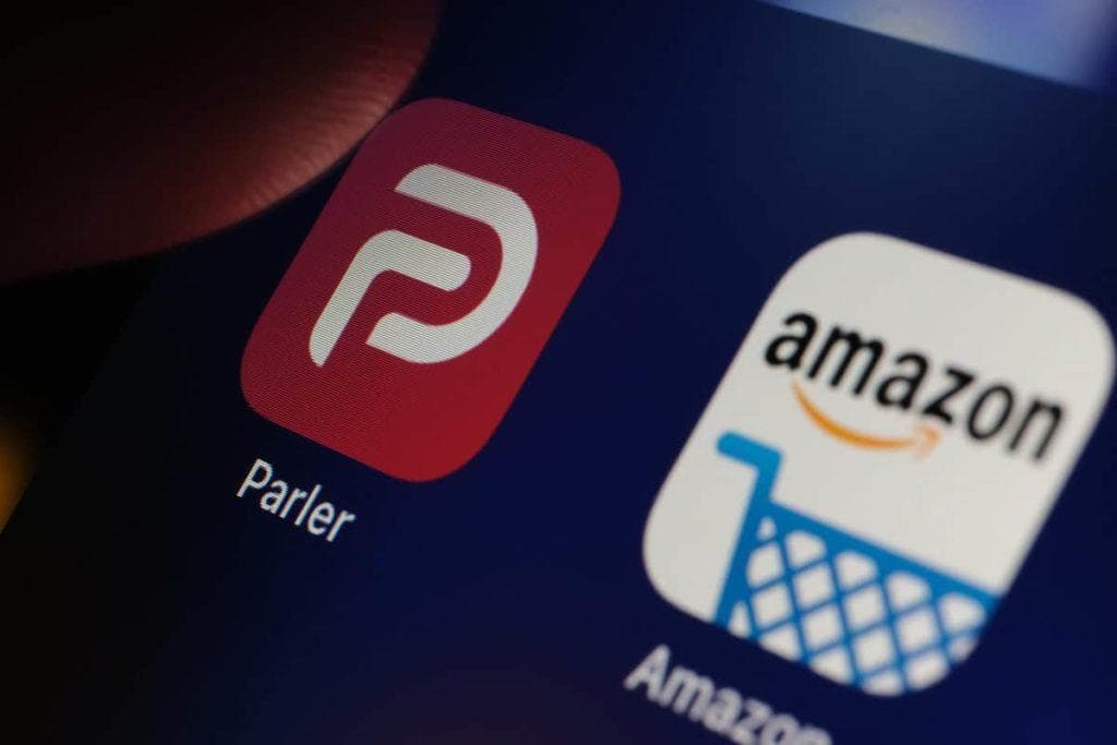 Parler app and Amazon app seen on the screen of iPad. Concept. Parler is a social media platform banned by Google, Apple and Amazon. Stafford, United Kingdom - January 11 2021.