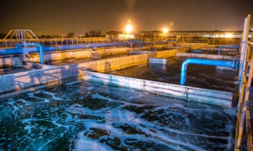 Modern wastewater treatment plant of chemical factory at night. Water purification tanks