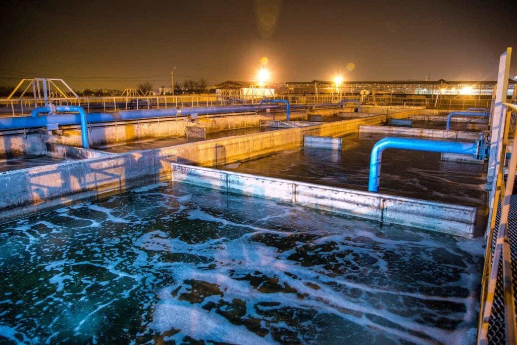 Modern wastewater treatment plant of chemical factory at night. Water purification tanks