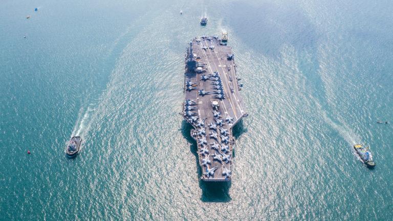 United States of America warship navy nuclear aircraft carrier, American military battleship navy ship carrier airplane full loading plane fighter jet aircraft, USA, Aerial view in open ocean.