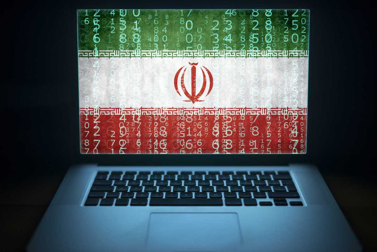 Iran internet and network security. Laptop with binary computer code and Iranian flag on the screen. Iranian hacker.