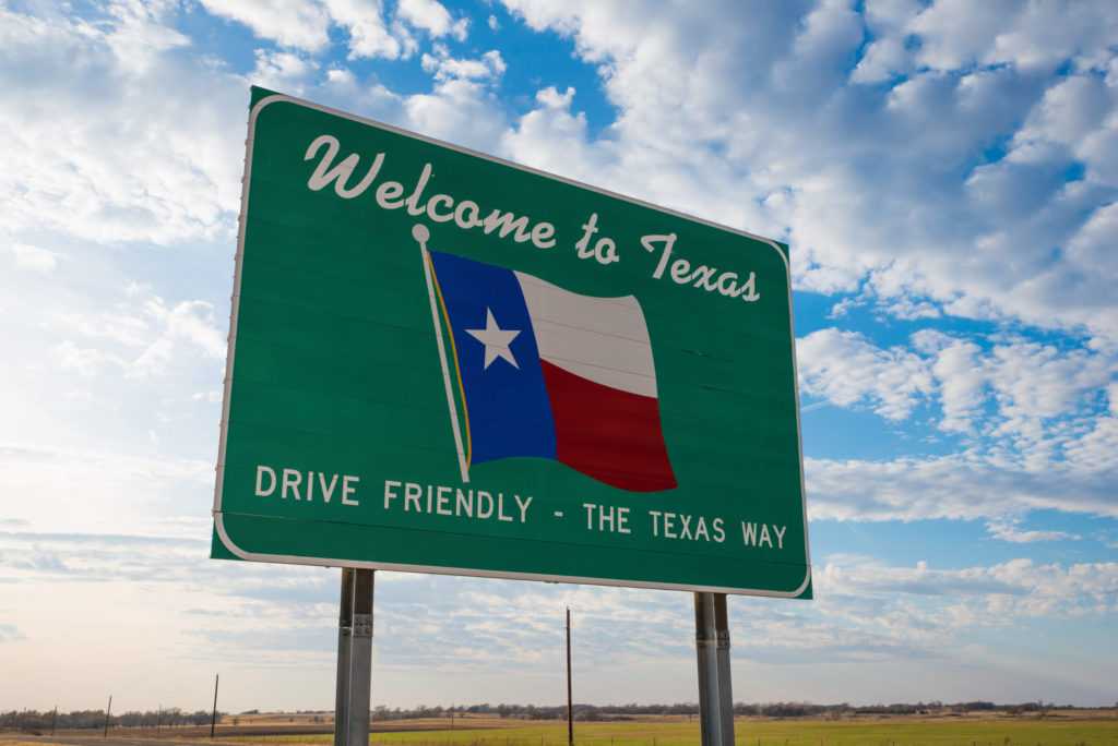 Welcome to Texas road sign in front of cloudy sky