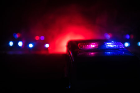 Police cars at night. Police car chasing a car at night with fog background. 911 Emergency response pSelective focus