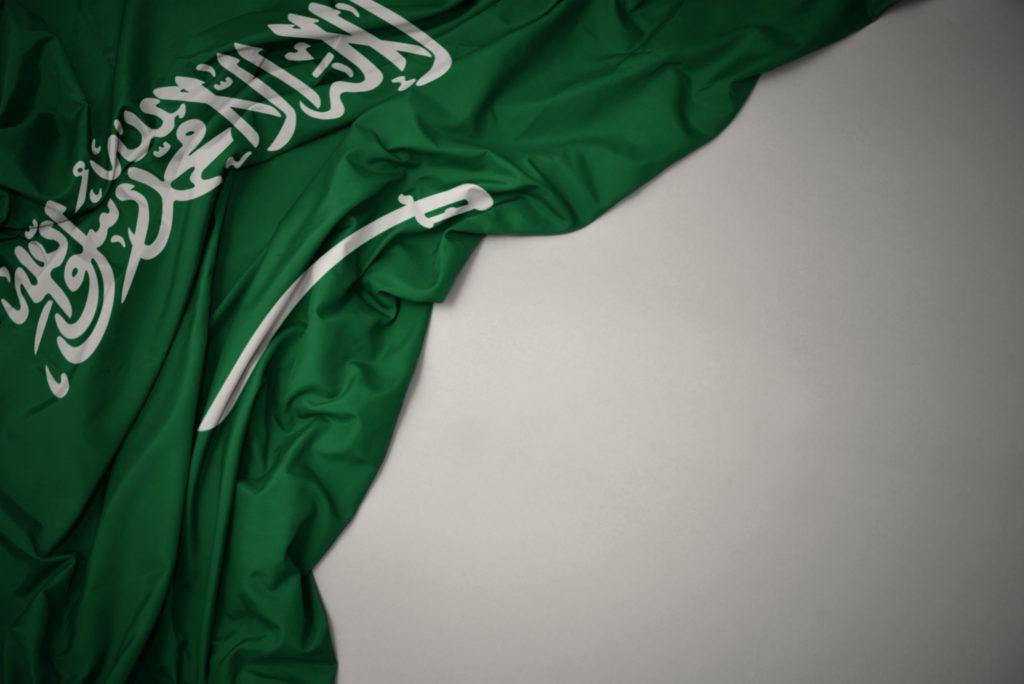 waving national flag of saudi arabia on a gray background.