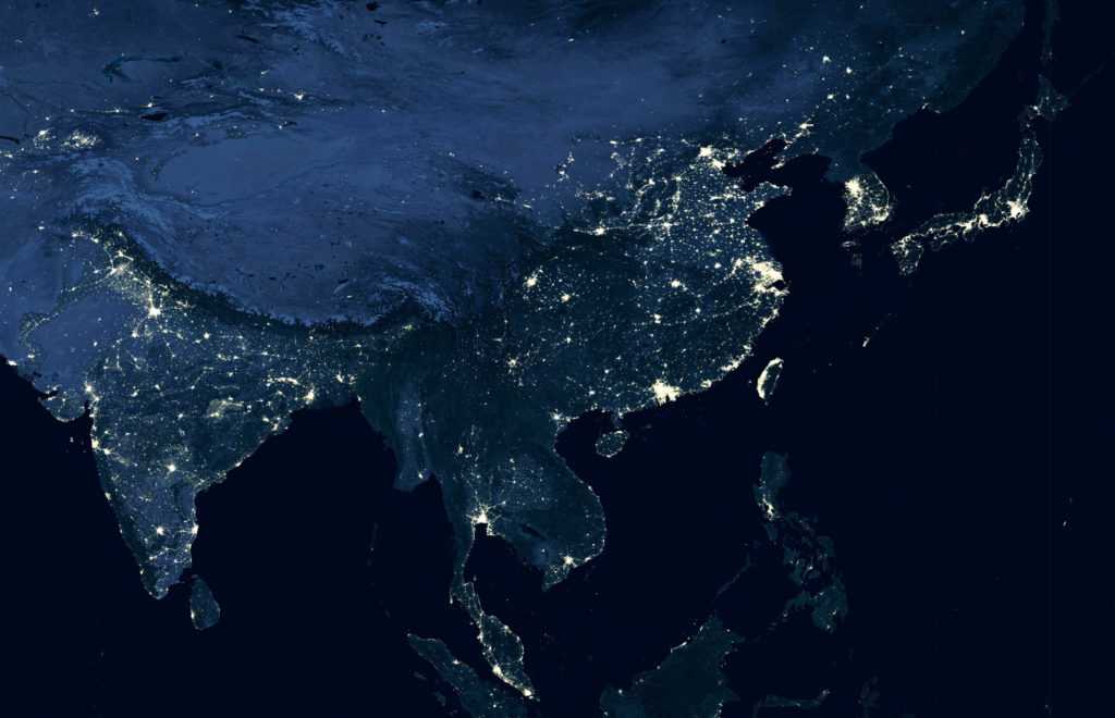 Earth at night, world map on satellite photo. City lights showing human activity in India, China, South Korea and Japan from space. Elements of this image furnished by NASA.