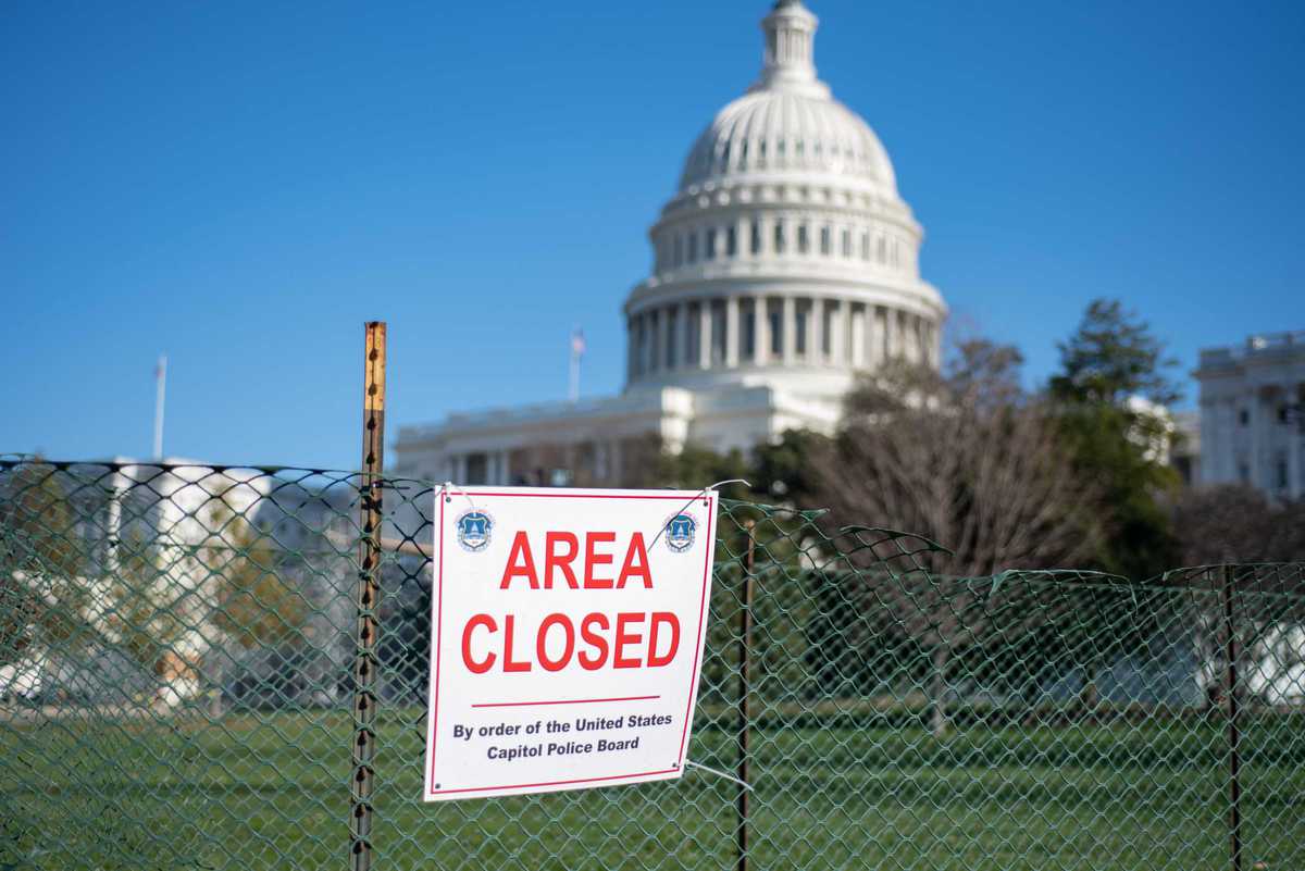 Washington, DC, USA - December, 23, 2020: Area Closed sigh on Fence on blureed United States Capitol Building background.