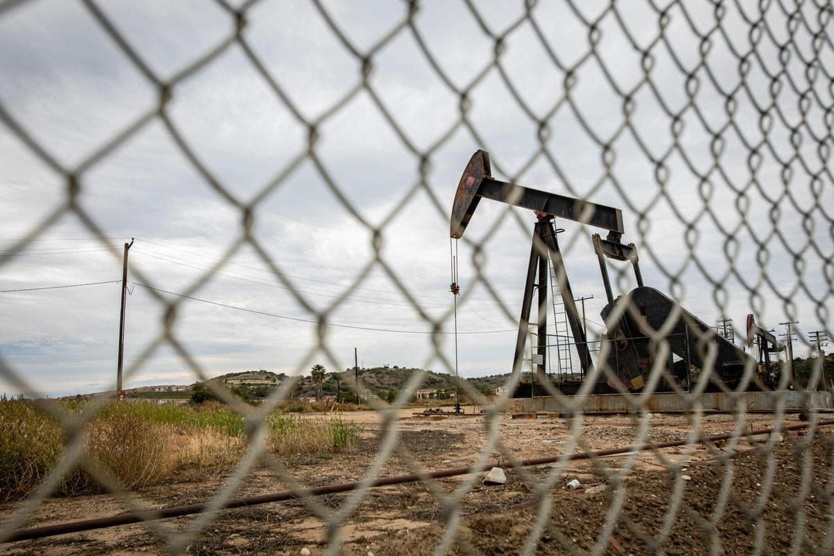 Oil Pump in Cloudy Rough Weather with Chain Link Fence